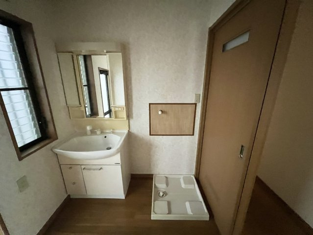 洗面化粧台と洗濯機置き場を備えた、使い勝手の良い洗面室です。洗面台には鏡や小物収納があり、毎日の身支度にも便利。室内には窓が設けられているため、自然光を取り込みやすく換気がしやすいのもポイントです。