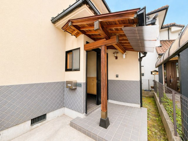 木の温もりを感じる玄関ポーチが印象的な外観です。屋根付きのため雨の日でも濡れにくく、出入りがしやすい設計です。落ち着いた外壁カラーと調和したデザインで、住まい全体に上品な印象を与えます。