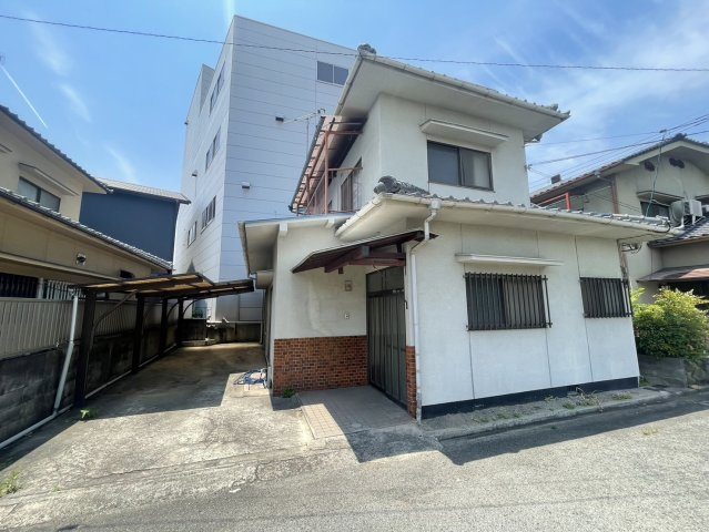 落ち着いた雰囲気の2階建住宅。和瓦屋根と白壁の外観はどこか懐かしく、風格のある佇まいです。玄関前には屋根付きのアプローチとカーポートがあり、雨天時の利便性も高め。前面道路は宅地（持分有）になります。