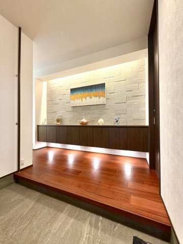 邸宅の顔にふさわしい、洗練された玄関ホール。間接照明に照らされた天然木のフロアと飾り棚が、ゲストを上品にお迎えします。毎日の出入りが豊かになる空間です。