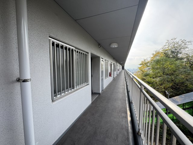 高台に位置する建物ならではの眺望が楽しめる開放的な廊下です。風通しや採光がよく、外の景色を感じながら移動できる点が魅力です。　朝の通勤・通学時など、四季折々の景色が楽しめそうです。