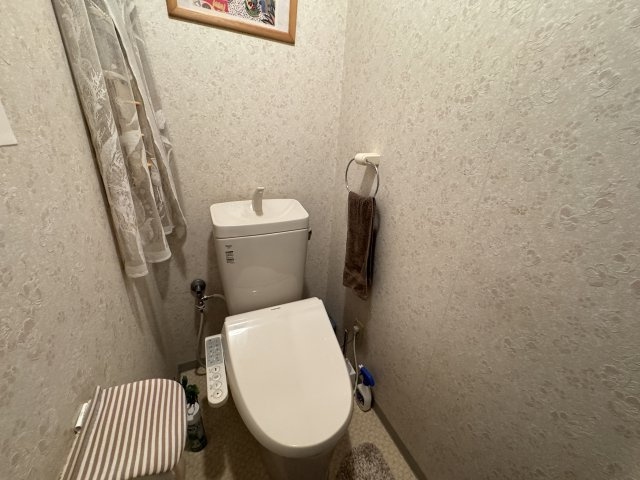 リフォームされたクロスが清潔感を引き立て、落ち着いた雰囲気のトイレ空間となっています。　温水洗浄便座が設置されており、快適性に配慮されており、使い勝手の良さが感じられます。