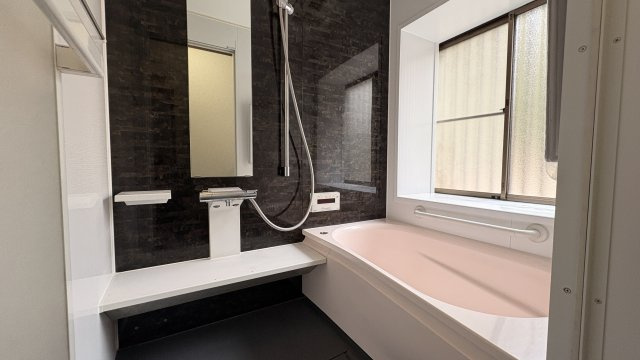 落ち着いたアクセントパネルが印象的な浴室。大きめの浴槽でゆったりと入浴でき、一日の疲れをしっかり癒せます。手すりも設置されており、小さなお子様やご高齢の方にも安心です。快適なバスタイムを楽しめます。