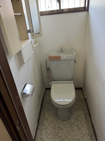 小窓から明かりが入り、手洗い付きのシンプルなトイレです。