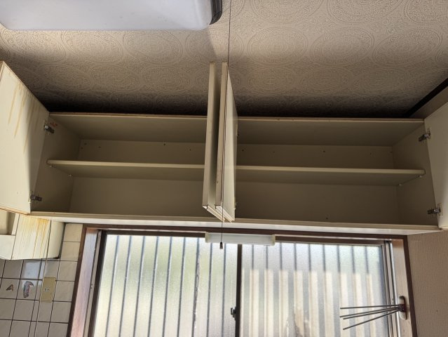 上部の空間を有効に活用した、調理器具が収まる吊り戸棚。