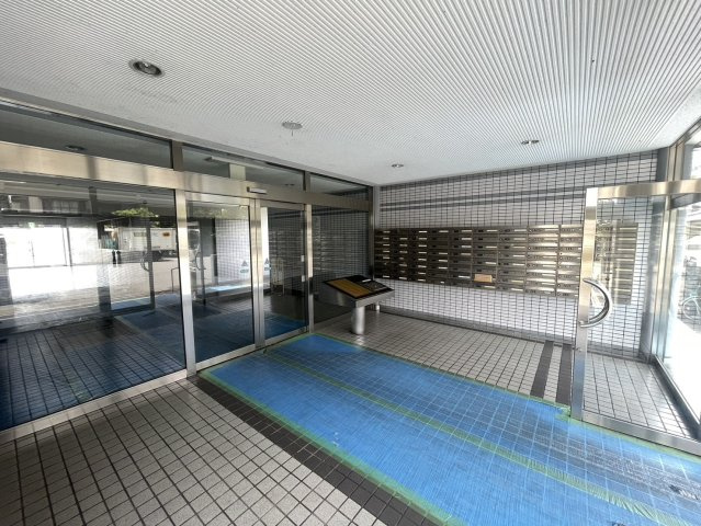 マンションのエントランスには各住戸用のメールボックスがまとめて設置されています。郵便物を帰宅時に確認しやすく、日々の生活動線にも配慮された共用スペースです。ガラス面を多く採用したエントランスです。
