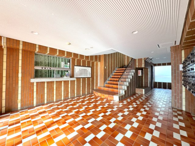 住まう方やゲストを心地よく迎える、洗練されたデザインのエントランスホール。手入れの行き届いた清潔感のある空間が、マンション全体の質の高さを物語っています。セキュリティ面でも安心感のある佇まいです。