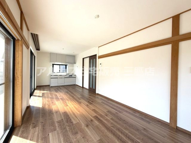 壁面の木枠デザインがアクセントになった、キッチンへとスムーズにつながる広々としたLDK。