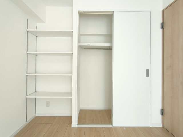 【洋室約5.6帖　収納】　ワイドなクローゼットを備え、衣類などをたっぷり収納可能。棚板の位置をお好みで動かせる可動棚が備わっております。