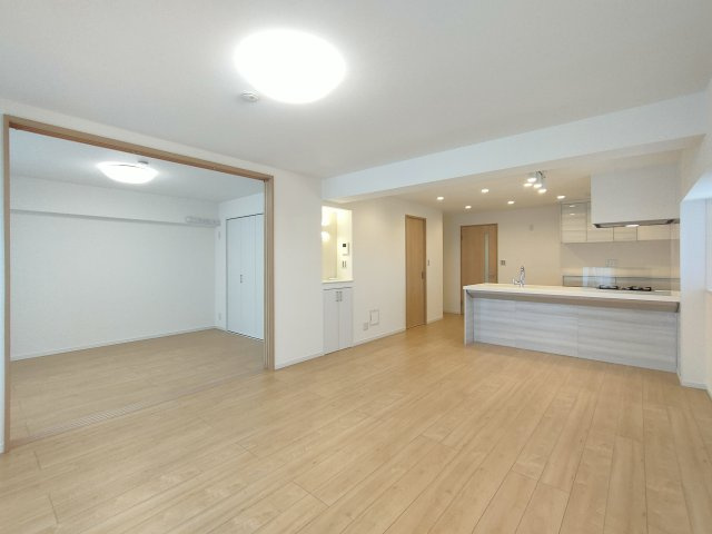 【LDK約17.0帖】　南東向きバルコニーに面した明るいリビング。柔らかな色合いのフローリングが穏やかな空間を演出します。カウンターキッチンからリビングの様子を伺える仕様です。