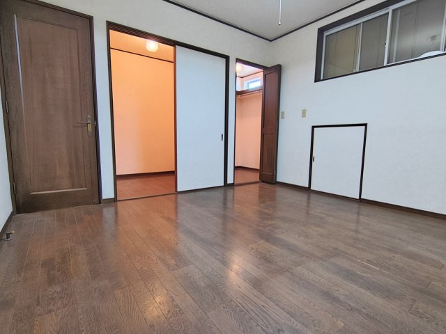 収納を備えた使い勝手の良い洋室。木目調の床が落ち着いた空間を演出し、家具も配置しやすい広さです。