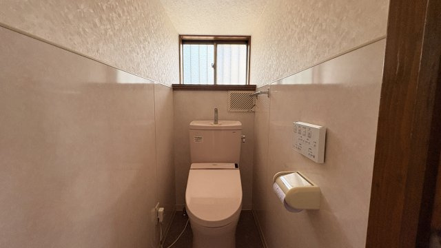 清潔感のあるトイレ空間です。温水洗浄便座付きで快適に使用できます。窓があり自然換気が可能なため、空気の入れ替えもしやすい設計です。手元操作のリモコンも備え、機能性にも配慮されています。