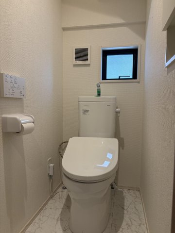 白を基調とした清潔感のあるトイレ。快適な温水洗浄便座付きです。換気扇に加えて小窓も設置されており、明るく通気性も抜群。大理石調のフロアクロスがさりげない高級感を演出します。