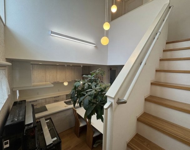 吹抜け空間とデザイン性のある照明が印象的な階段スペース。上下階のつながりを感じられる開放的な設計で、室内全体に明るさをもたらします。来客時にも印象に残る、魅力的な空間となっています。