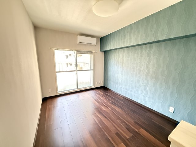 ブルーのアクセントクロスが印象的なお部屋で落ち着きのあるダークブラウンのフローリングとの組み合わせが上質な空間を演出。窓から自然光が差し込み明るく開放的。エアコン付きのため初期費用も抑えやすいです。