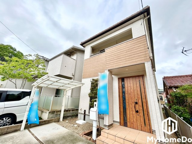 重厚な木目調ドアとタイルのステップが迎え入れる、上品でスタイリッシュなアプローチ。
