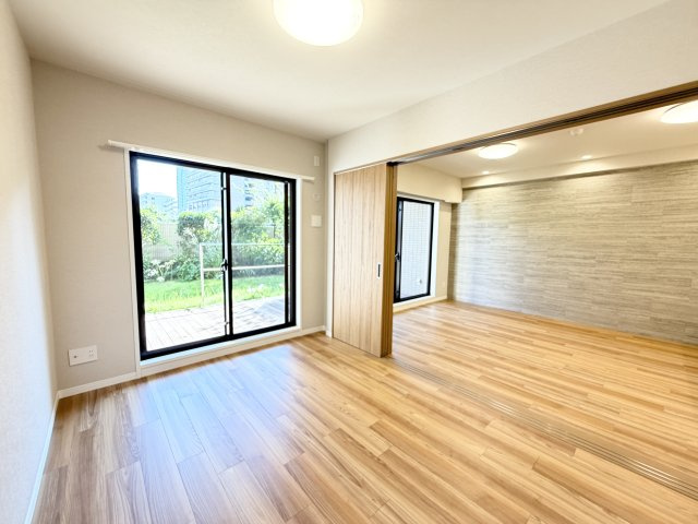 大きな窓から専用庭の緑と差し込む光を楽しめる明るい居室空間。引き戸を開放すれば隣の部屋と一体化し、さらに開放的な大空間として活用できます