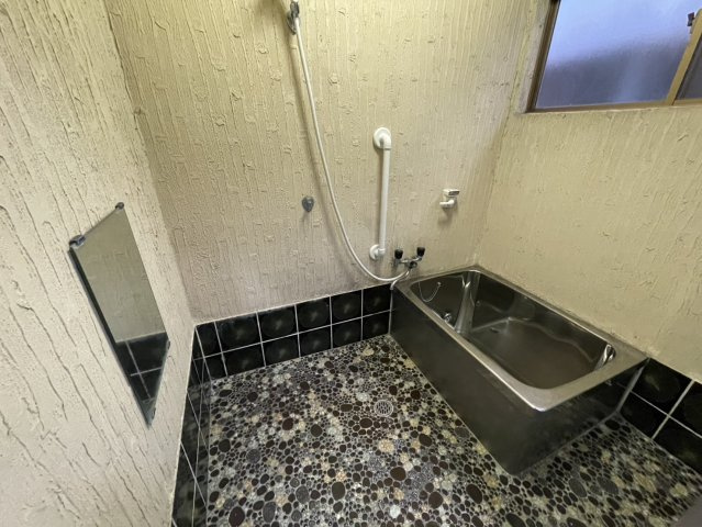 石張り調の床が印象的な趣ある浴室空間。コンパクトながら使いやすい浴槽を備え、ゆったりと入浴時間を楽しめます。窓付きで自然換気が可能なため湿気がこもりにくく、清潔に保ちやすい点も魅力です。