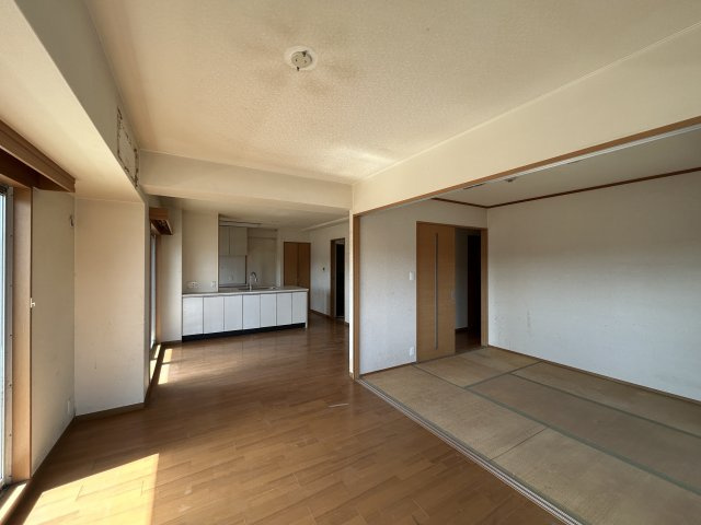 キッチンがリビングと一体となった間取りで、ご家族との会話を楽しみながら料理ができるレイアウト。隣接する和室の引き戸を開ければ、さらに広々とした空間として利用することも可能です。リフォーム前の写真です。