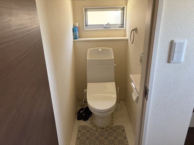 手洗い一体型で空間を有効活用したトイレ。小窓から自然光が入り、明るく清潔感のある空間です。