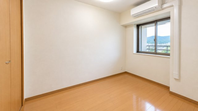 窓の外に山並みを望む4.5帖の洋室です。白を基調とした壁と明るい木目調のフローリングがすっきりとした印象を演出。コンパクトながら使いやすく子供部屋や書斎趣味部屋などライフスタイルに合わせて活用できます