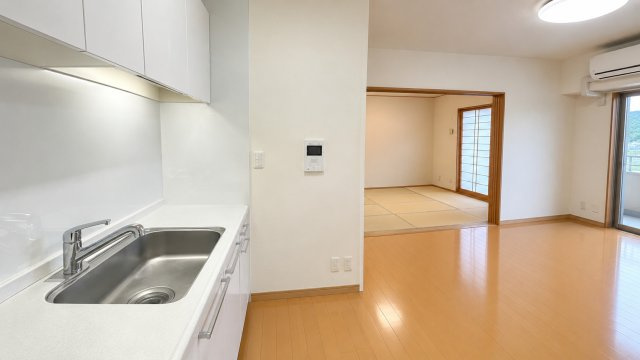 リビング・和室を見渡せる配置で家族の様子を感じながら調理ができるキッチンです。白を基調とした清潔感あるデザインで上下に収納スペースも確保。LDKとのつながりがよく配膳や片付けやすい使い勝手良い空間です