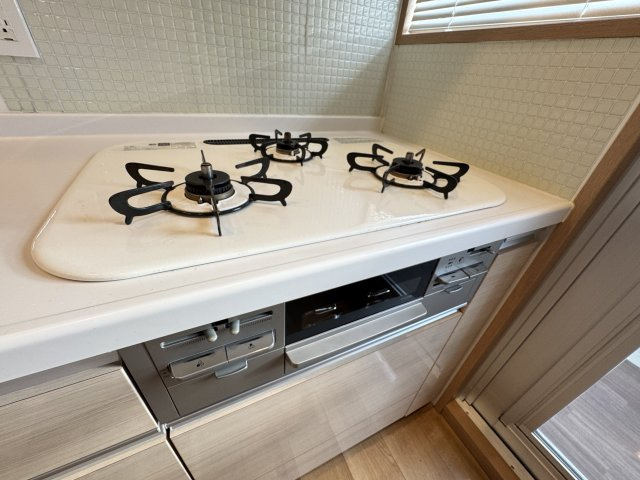 3口ガスコンロを備えた使い勝手の良いキッチン設備。複数の料理を同時に進めることができるため、忙しい朝や夕食の準備もスムーズに行えます。グリルも備わっており、焼き魚などの調理にも便利。