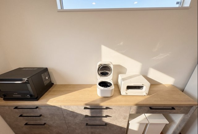 キッチン背面には大容量の造作収納を設置。調理家電や食器類、食品ストックまでまとめて収納できるため、キッチン周りをすっきり保てます。家電置場としても活用でき、毎日の家事効率を高めてくれる便利な空間です。