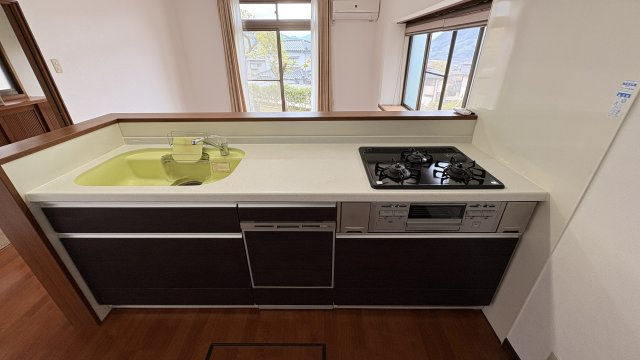 対面式のキッチンは、リビングを見渡せる開放的な設計となっています。3口コンロ付きで同時調理がしやすく、作業効率も良好です。シンクと作業スペースにも余裕があり、料理や後片付けもスムーズに行えます。