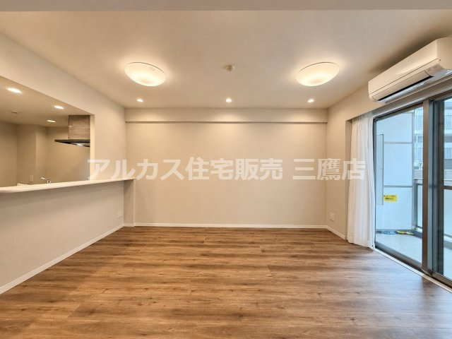 大きな窓から光が差し込む明るいリビングスペース。バルコニーへ続くサッシの横にはエアコンも完備されています