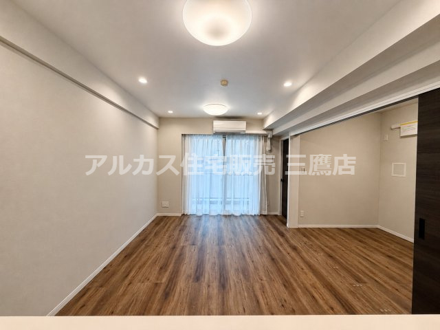 キッチン側から見たリビングダイニング。木のぬくもりを感じるフローリングと落ち着いた照明が快適な空間を演出します。