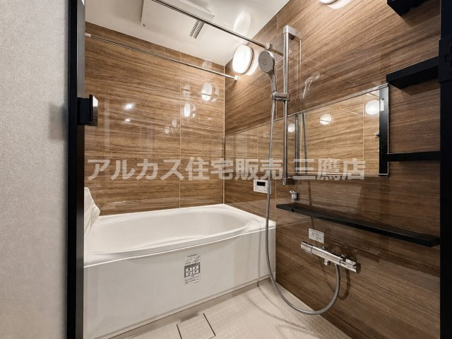 高級感のある木目調パネルで仕立てられた浴室。手すり兼用のシャワースライドバーや浴室乾燥機など、機能性も充実しています。