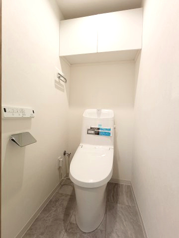 【トイレ】　スッキリとしたデザインの温水洗浄便座付きトイレ。小物やトイレットペーパーなどが目につかない状態で収納できます。