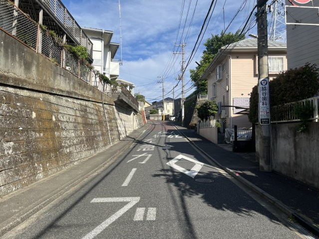 物件へと続く、閑静な住宅街の坂道。交通量が少なく、落ち着いた環境です。