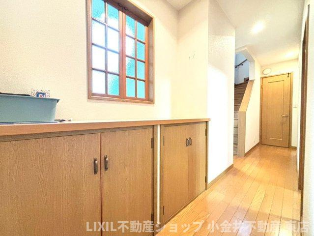 【内装】現地写真：1階廊下には容量もある収納付。また、ダイニングに繋がる窓はご家族のお帰りの際、顔をあわせて会話もできる会話の弾む間取りです。