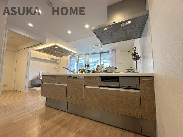 開放感のあるすっきりとしたキッチンで、木目調のシステムキッチンがリビング空間に溶け込んでいます。