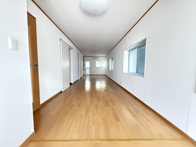 11帖の広々とした洋室はリビングとしてもダイニングとしても活用できるゆとりの空間。縦に伸びる間取りが奥行きを感じさせ、家具配置の自由度も高いのが特徴です。大きな窓から光が差し込み明るいです（隣建物分）