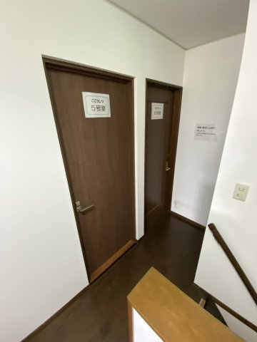 各ドアには「5号室」「6号室」などのプレートが設置され、入居者様のプライバシーに配慮した施設運営がなされています。