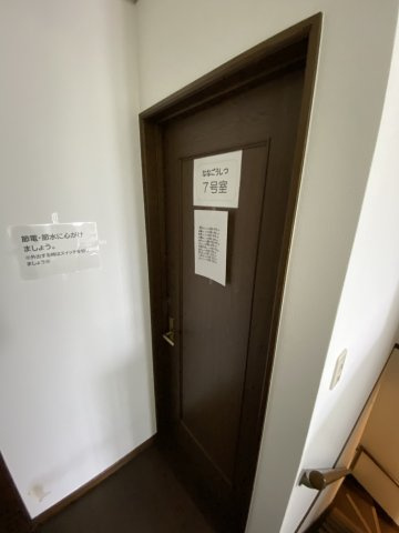 共有スペースや廊下には、節電・節水への協力案内や各室のプレートが整然と掲示されており、運営事業者の丁寧な管理状況が伺えます。