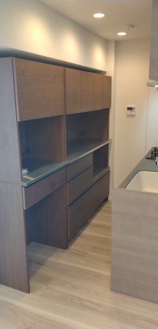 上部に吊り戸棚が設置された、浄水器付きのシステムキッチンです