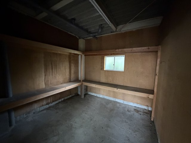 1階倉庫の内部。棚板が設置されており、小窓があります
