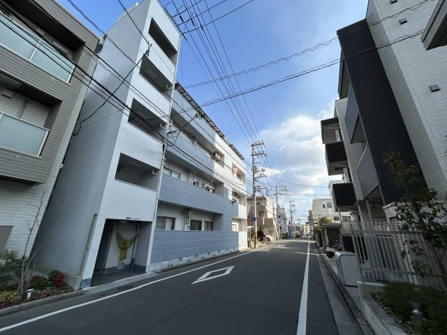 前面道路は見通しが良く、車や自転車の出入りもしやすい立地です。周辺は中高層マンションが並ぶエリアで、生活動線が整った住環境。都市部らしい利便性と落ち着きを兼ね備えています。