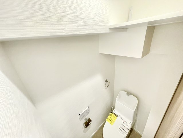 新設トイレ。上部には収納用のカウンター棚もございます。
