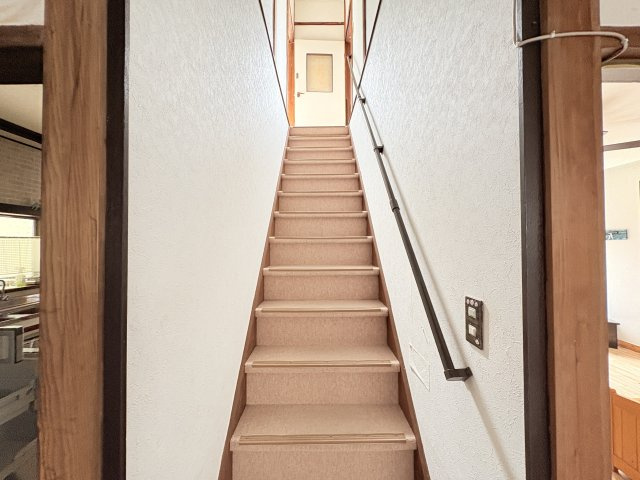 2階へとつながる階段には手すりが設けられており、上り下りをサポート。明るい色合いの壁と木部を組み合わせた、落ち着きのある空間です。各段には滑り止めも備えられていて安心して上り下り出来ます。