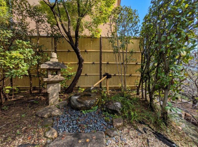 石灯籠や庭石と植栽を配置した、日本庭園らしい趣を感じる一角。竹垣を背景に緑が美しく映え、落ち着きのある景観をつくり出しています。眺めるだけでなく、庭を歩きながら季節の変化や和の風情を楽しめます。