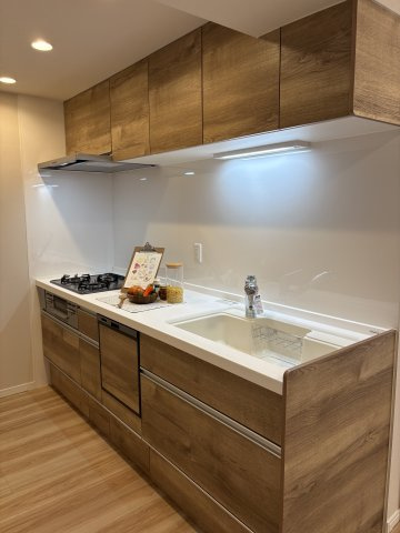 温かみのある木目調のデザインが魅力的なシステムキッチン。上下に豊富な収納スペースを備え、散らかりがちな調理器具もすっきり片付きます。お料理がもっと楽しくなる、清潔感溢れる空間です。