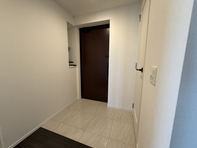 白とダークブラウンのコントラストが美しい玄関スペース。ゆとりある広さで、急な来客時も安心です。