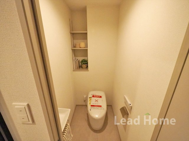 壁面に収納棚を備えた清潔感のあるトイレです！ペーパーや小物をすっきり整理できて快適に使えますね♪