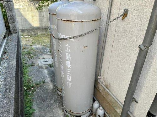 敷地内にはプロパンガスボンベが設置されており、キッチンや給湯、暖房などに対応。設置状態も安定しており、安全性に配慮されたチェーン固定も確認できます。
