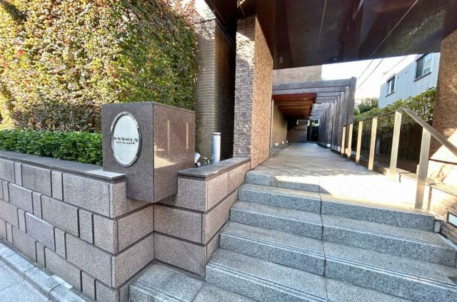 重厚感ある石張りと緑の潤いが調和するエントランスアプローチ。日常に特別感をもたらす空間です。